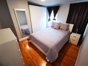 1 dormitorio con 1 cama grande y espejo en Location+Comfort+Convenience, en Boston