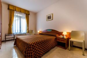 1 dormitorio con cama, escritorio y ventana en Cannaregio II Apartments, en Venecia