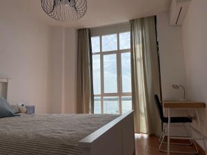 um quarto com uma cama, uma secretária e uma janela em Apartamento Atardeceres em Ayamonte