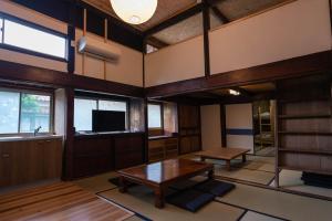 ein Wohnzimmer mit einem Tisch und einem TV in der Unterkunft guesthouse碧 in Okinoshima