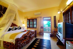 um quarto com uma cama e uma televisão em Shining Angkor Boutique Hotel em Siem Reap