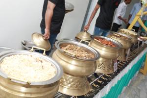 een rij metalen schalen van voedsel op een tafel bij HYDEPARK REGENCY in Palakkad