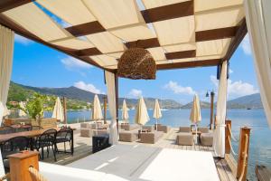restauracja z krzesłami i stołami oraz widokiem na wodę w obiekcie Naxos Beach Hotel w mieście Marmaris
