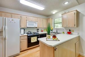 uma cozinha com armários de madeira e um frigorífico branco em Lakefront Hot Springs Home with Furnished Deck! em Hot Springs