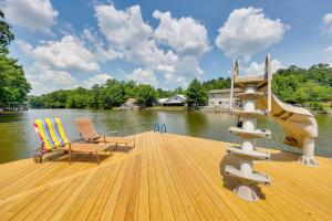 a wooden dock with two chairs and a staircase on a lake at Lakefront Hot Springs Home with Furnished Deck! in Hot Springs