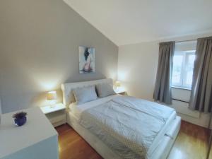 a bedroom with a white bed and a window at Apartment Anita in Umag