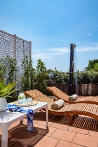 eine Terrasse mit 2 Stühlen, einem Tisch und einem Sonnenschirm in der Unterkunft [Mare privato] Villa Casamare in Acireale
