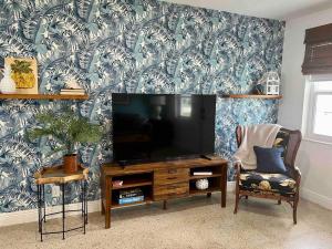 sala de estar con TV de pantalla plana y silla en New! Tropical Hideaway near Beach! Tons of Parking, en Boynton Beach