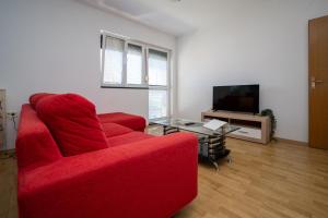 a living room with a red couch and a tv at Apartments with a parking space Sali, Dugi otok - 16324 in Sali