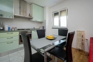 a kitchen with a table with chairs and a bowl of bananas on it at Apartments with a parking space Sali, Dugi otok - 16324 in Sali