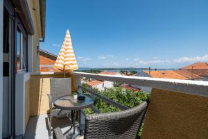 einen Balkon mit einem Tisch und Stühlen auf einem Gebäude in der Unterkunft Apartments with a parking space Sali, Dugi otok - 16324 in Sali