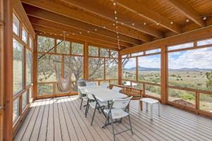 a large wooden porch with a table and chairs on it at Casa de Luna in Alpine