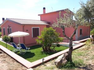 a pink house with a garden and a tree at Antico Casolare Sorso-Tourist Rental in Sorso