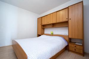 a bedroom with a bed and wooden cabinets at Apartments by the sea Zaglav, Dugi otok - 17788 in Sali