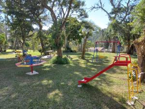 een park met kleurrijke speeltoestellen in het gras bij Sítio Toa Toa in São Roque