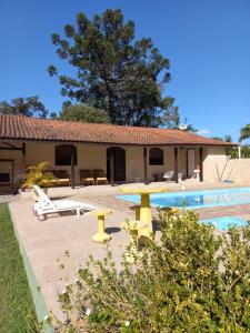 a house with a pool and a table and chairs at Sítio Toa Toa in São Roque