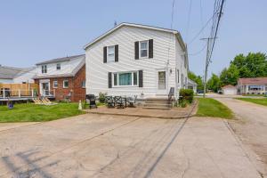 a white house with a picnic table in front of it at Home with Screened-In Porch Less Than 1 Mi to Lake Erie in Port Clinton