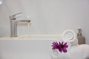 Baño blanco con toalla y lavamanos en Alkyoni Apartments, en Agios Nikolaos