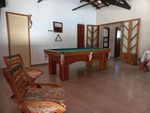 a room with a pool table and two chairs at Sítio Toa Toa in São Roque