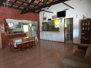 a living room with a table and chairs and a kitchen at Sítio Toa Toa in São Roque