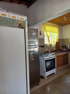 a kitchen with a refrigerator and a stove at Sítio Toa Toa in São Roque