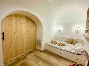een slaapkamer met een bed en een grote houten deur bij Cozy flat by the sea in the Old Town in Vieste