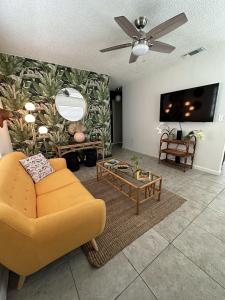 sala de estar con sofá amarillo y TV en Miami's Cozy Tropical Getaway, en Miami