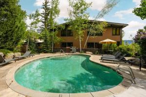 a swimming pool with chairs and a house at Aspenwood One Bedroom J3 in Snowmass Village