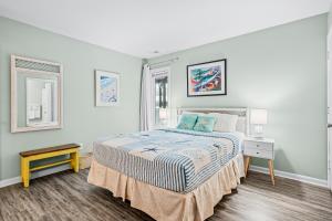 a white bedroom with a bed and a window at Colony by the Sea #201 in Indian Beach
