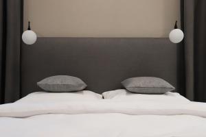 sypialnia z białym łóżkiem z 2 poduszkami w obiekcie Apartamenty Legionów 40A - A27 w Kaliszu