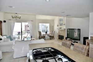 a living room with white furniture and a tv at Beach House located in quiet community. in Oxnard