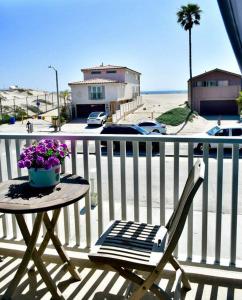 a table and a chair on a balcony with the beach at Beach House located in quiet community. in Oxnard