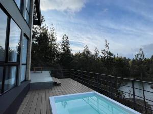 un balcón con piscina en la parte superior de una casa en Aqua Guatapé - Lakeside Luxury Villa, en Guatapé