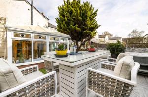 a patio with a table and chairs and a house at The Mews - less than 1km to City Centre - Stadium - Castle - 10 min walk in Cardiff