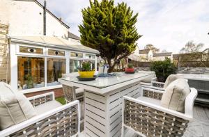 a patio with a table and chairs and a house at The Mews in Cardiff