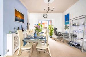 a dining room with a table and chairs and a clock at The Mews - less than 1km to City Centre - Stadium - Castle - 10 min walk in Cardiff