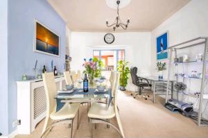 a dining room with a table and chairs and a clock at The Mews in Cardiff