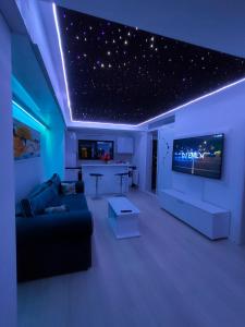 ein Wohnzimmer mit einem Sofa und einem TV mit Sternen an der Decke in der Unterkunft Seven Luxury in Mamaia Nord – Năvodari