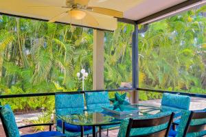 eine Terrasse mit einem Glastisch, Stühlen und Palmen in der Unterkunft The Rainbow Villa in Naples