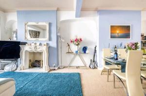 Il comprend un salon doté de murs bleus, d'une table et d'une cheminée. dans l'établissement The Mews, à Cardiff