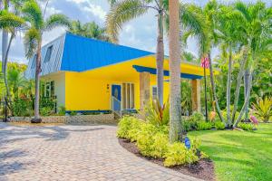 a yellow and blue house with palm trees at The Rainbow Villa in Naples