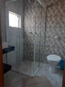 a shower stall with a toilet in a bathroom at Suítes Caninana in São Thomé das Letras