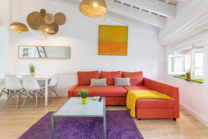 sala de estar con sofá rojo y mesa en Baron Suites Reina, en Valencia