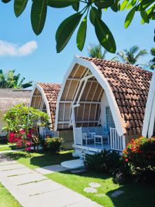 a group of cottages with a roof at Dream CoWork Hotel in Kuta Lombok