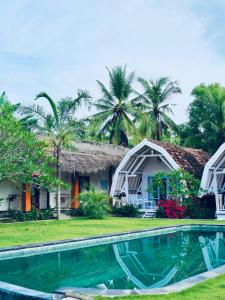 a villa with a swimming pool in front of a resort at Dream CoWork Hotel in Kuta Lombok