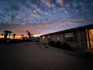 a building with a sunset in the background at Bodhi House, Joshua Tree National Park in Twentynine Palms