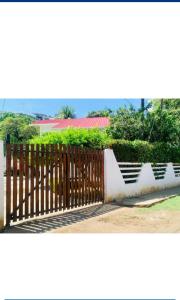 una puerta de madera frente a una valla blanca en Cabañas Don Rafa Santa Marta en Santa Marta