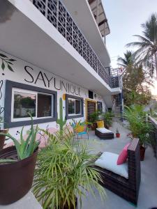 un bâtiment avec une terrasse avec des plantes devant lui dans l'établissement Sayunique Boutique Hostal, à Sayulita