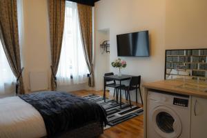 Habitación de hotel con cama y lavadora en S.H Apartments, en Glasgow