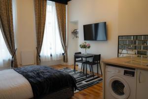 um quarto de hotel com uma cama e uma máquina de lavar roupa em S.H Apartments em Glasgow